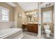 Bright bathroom featuring a tub, vanity, toilet, and neutral colors at 7685 Lake Angelina Dr, Mount Dora, FL 32757