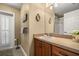 Well-lit bathroom with a vanity, framed mirrors, and a shower-tub combo provides essential functionality at 7685 Lake Angelina Dr, Mount Dora, FL 32757