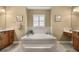 Relaxing bathroom featuring a soaking tub, tiled walls, and neutral decor at 7685 Lake Angelina Dr, Mount Dora, FL 32757