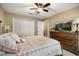 Cozy bedroom featuring a comfortable bed, wooden dresser with TV, and ample closet space at 7685 Lake Angelina Dr, Mount Dora, FL 32757