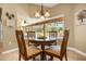 Cozy breakfast nook with backyard views and a charming chandelier above the round dining table at 7685 Lake Angelina Dr, Mount Dora, FL 32757