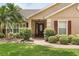 Charming home entrance featuring a beautifully landscaped yard and stylish front door with an oval glass window at 7685 Lake Angelina Dr, Mount Dora, FL 32757