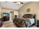 Comfortable bedroom boasts a ceiling fan, neutral paint and an ensuite bathroom at 7685 Lake Angelina Dr, Mount Dora, FL 32757