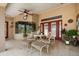 Covered patio area with ceiling fan, comfortable seating, and views of the backyard at 7685 Lake Angelina Dr, Mount Dora, FL 32757