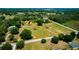 Scenic aerial view of a house nestled in a green landscape with a road and distant water at 7701 Groveland Farms Rd, Groveland, FL 34736