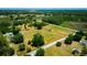 Wide aerial view of house and property showing a lake and forest in the background at 7701 Groveland Farms Rd, Groveland, FL 34736