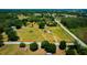 Aerial view featuring a house on a grassy lot with trees and distant water bodies at 7701 Groveland Farms Rd, Groveland, FL 34736