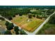 Aerial view of a property with defined boundaries, a home, lush greenery, and a roadway at 7701 Groveland Farms Rd, Groveland, FL 34736
