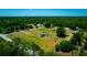 Expansive aerial view of property featuring verdant land, mature trees, and a cozy home under a clear blue sky at 7701 Groveland Farms Rd, Groveland, FL 34736