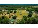 Overhead view of a homestead amid verdant surroundings with a clear road nearby and pond in the distance at 7701 Groveland Farms Rd, Groveland, FL 34736
