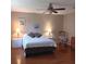 Bright bedroom featuring a queen bed, two nightstands with lamps, ceiling fan, and hardwood floors at 8431 Sw 93Rd Place # F, Ocala, FL 34481