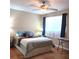 Cozy bedroom with a queen bed, ceiling fan, and a window with sheer curtains and navy blue drapes at 8431 Sw 93Rd Place # F, Ocala, FL 34481