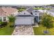 Inviting aerial view of the home showing the paver driveway and manicured lawn at 8492 Hartford Way, Mount Dora, FL 32757