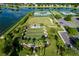 Aerial view of recreational facilities, including tennis and bocce ball courts, set near a scenic pond at 8492 Hartford Way, Mount Dora, FL 32757