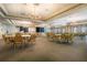Large, well-lit ballroom with multiple tables, chairs, chandeliers, and a stage at 8492 Hartford Way, Mount Dora, FL 32757