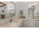 Bright bathroom featuring double sinks, granite counters, vanity cabinets and modern fixtures at 8492 Hartford Way, Mount Dora, FL 32757