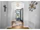 Welcoming foyer with wood floors, decorative lighting, and elegant front door at 8492 Hartford Way, Mount Dora, FL 32757