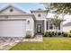 Charming single-story home with a well-maintained lawn and a welcoming front entrance and attached garage at 8492 Hartford Way, Mount Dora, FL 32757