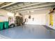 Large, clean garage with epoxy flooring, overhead storage, and well-organized tools and equipment at 8492 Hartford Way, Mount Dora, FL 32757