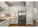 Bright kitchen featuring stainless steel refrigerator and modern white cabinetry at 8492 Hartford Way, Mount Dora, FL 32757