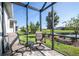 Relaxing screened patio with comfortable seating, offering serene views of the pond and lush backyard at 8492 Hartford Way, Mount Dora, FL 32757