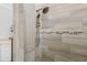 Modern shower with stylish tile, mosaic accent, and adjustable shower head adds a touch of luxury to this home at 8492 Hartford Way, Mount Dora, FL 32757