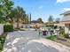 Wide backyard with concrete patio featuring outdoor seating, grill, and tropical landscaping at 919 Medira Dr, The Villages, FL 32159