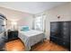 Cozy bedroom featuring hardwood floors, neutral walls, black dresser and bright window at 919 Medira Dr, The Villages, FL 32159