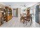 Bright dining area with tile flooring, a wooden table set, and a view into the adjacent living spaces at 919 Medira Dr, The Villages, FL 32159