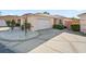 Beige single-Gathering home with a two-car garage, white rock landscape, and a concrete driveway in a sunny, pleasant neighborhood at 919 Medira Dr, The Villages, FL 32159