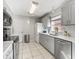 Efficient kitchen featuring stainless steel appliances, gray cabinets, tile floors, and a window for natural light at 919 Medira Dr, The Villages, FL 32159