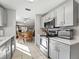 Functional kitchen with stainless steel appliances, gray cabinetry, and a view into the dining and living areas at 919 Medira Dr, The Villages, FL 32159