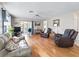 Bright living room with hardwood flooring, comfortable seating, and a glass sliding door to the backyard at 919 Medira Dr, The Villages, FL 32159