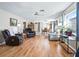 Spacious living room featuring hardwood floors, neutral walls, ceiling fan and comfortable leather furnishings at 919 Medira Dr, The Villages, FL 32159