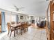 Open concept living and dining area with tile and wood flooring, ceiling fans, and sliding glass doors to the patio at 919 Medira Dr, The Villages, FL 32159