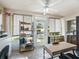 Bright sunroom with tiled floor, ceiling fan, shelving, work space and door to the backyard at 919 Medira Dr, The Villages, FL 32159