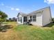 Home's rear exterior showing the sunroom, grill, and spacious yard at 951 Chapman Loop, The Villages, FL 32162