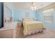 Comfortable bedroom with blue walls, ceiling fan, and floral bedding at 951 Chapman Loop, The Villages, FL 32162