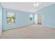 Light-filled bedroom with carpet, blue walls, and bright windows at 951 Chapman Loop, The Villages, FL 32162