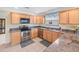 A kitchen featuring stainless steel appliances, tile floors, and wooden cabinets at 951 Chapman Loop, The Villages, FL 32162