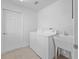 Well-lit laundry room with a washing machine, utility sink, and tiled floor at 951 Chapman Loop, The Villages, FL 32162