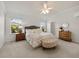 Bright main bedroom featuring plush carpet, a tufted headboard, and dual windows at 951 Chapman Loop, The Villages, FL 32162