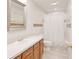 Classic bathroom with warm wood cabinetry, ample counter space, and a shower with decorative tile accents at 987 Princeton Dr, Clermont, FL 34711