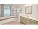 A primary bathroom with a large tub, separate shower, and granite countertop at 987 Princeton Dr, Clermont, FL 34711