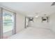 A neutral bedroom with carpet, ceiling fan, and large windows adorned with decorative window treatments at 987 Princeton Dr, Clermont, FL 34711
