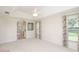 Spacious bedroom featuring tray ceilings, neutral carpet and access to the attached bathroom at 987 Princeton Dr, Clermont, FL 34711