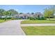 Inviting single-story home with lush green lawn, curved driveway, and mature trees at 987 Princeton Dr, Clermont, FL 34711