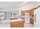 Well-lit kitchen featuring tile floors, island, and white appliances at 987 Princeton Dr, Clermont, FL 34711