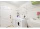 Functional laundry room featuring modern appliances, shelving, and a utility sink, making chores a breeze at 987 Princeton Dr, Clermont, FL 34711