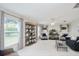 Open living room featuring a large bookshelf, plush seating, and bright natural light at 987 Princeton Dr, Clermont, FL 34711